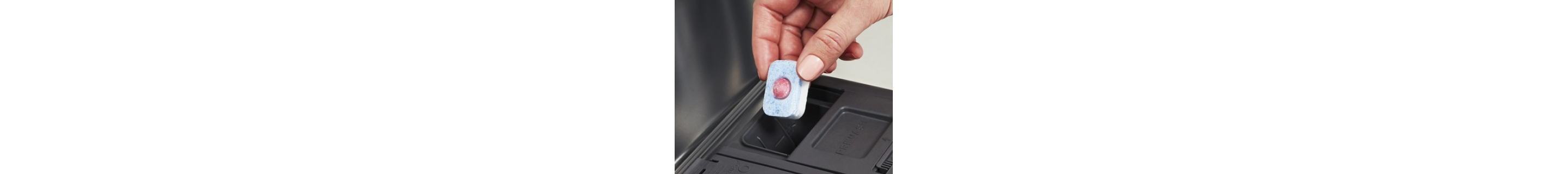 Person placing tablet in dishwasher dispenser