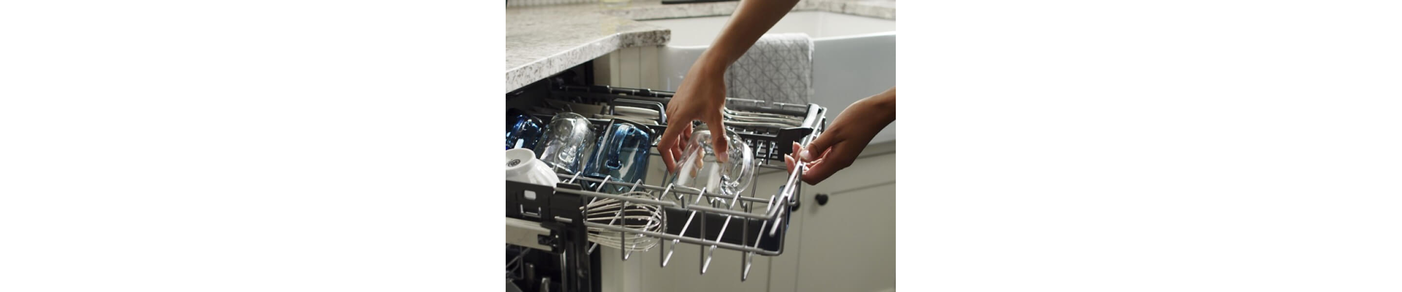 Person placing glass on dishwasher rack