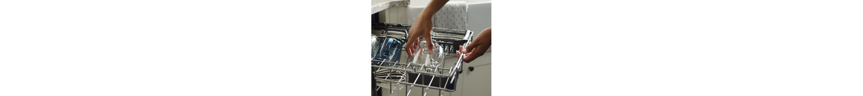 Person placing glass on dishwasher rack