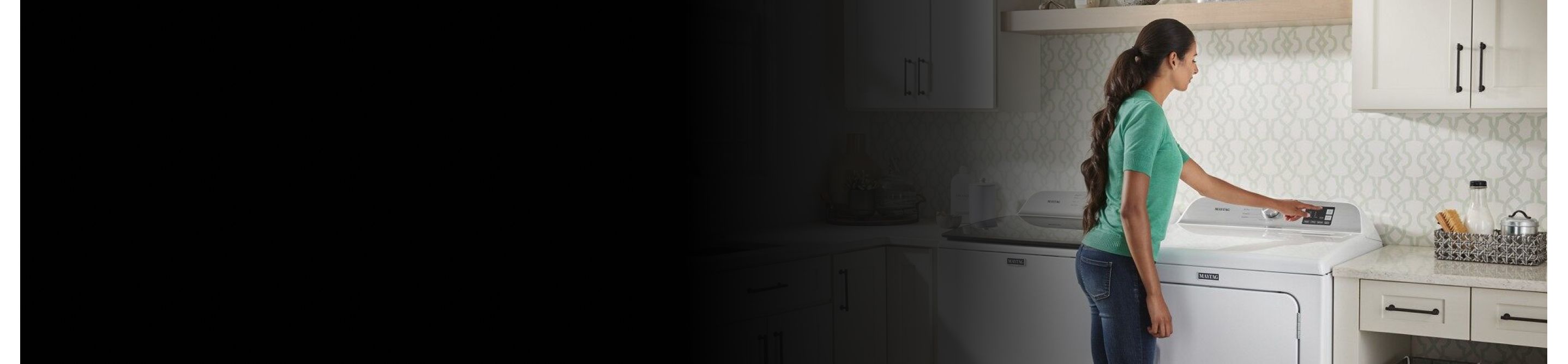 User pressing button on white front load dryer