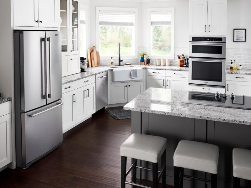 Cooktop on kitchen island surrounded by granite countertop