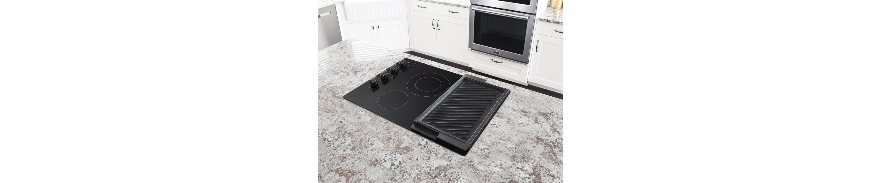 Maytag® electric cooktop with a reversible grill set in a granite counter top