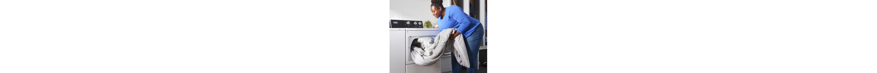 Person loading a comforter in a top load dryer