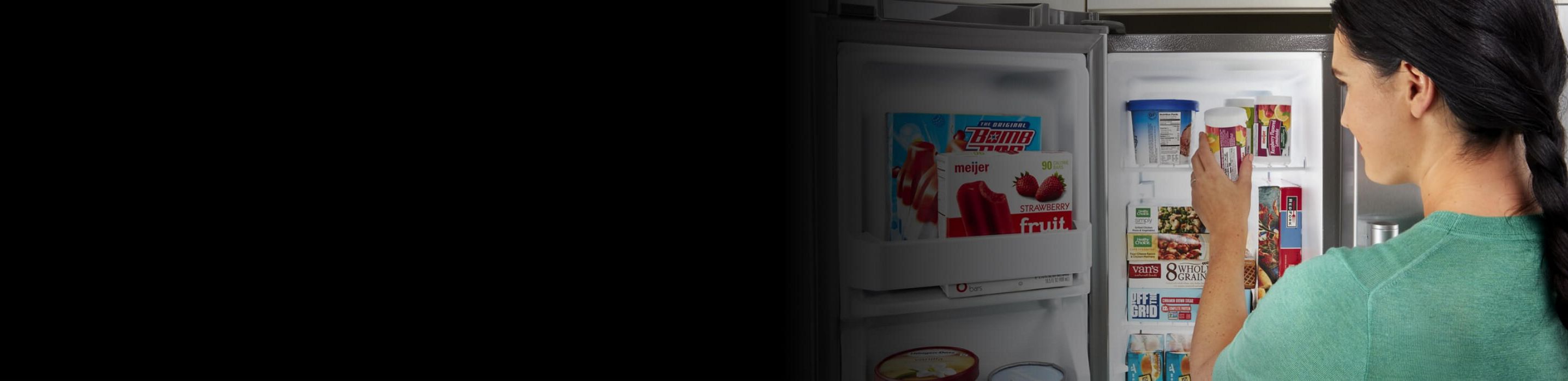 Woman standing in front of an open freezer