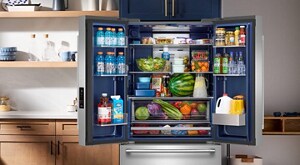  Open Maytag® refrigerator with Arctic Blue interior stocked with food