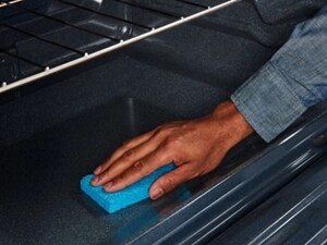 Person cleaning the interior of an oven