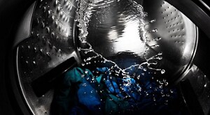 Clothes tumbling with water inside a washing machine