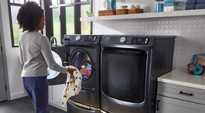 Person loading clothes into a Maytag® front load washer 