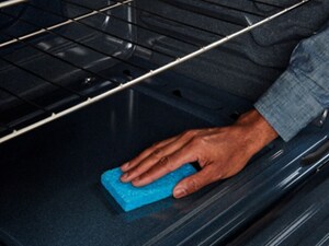 Person wiping out the inside of an oven