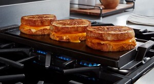 Grilled cheese sandwiches on a griddle above a gas burner
