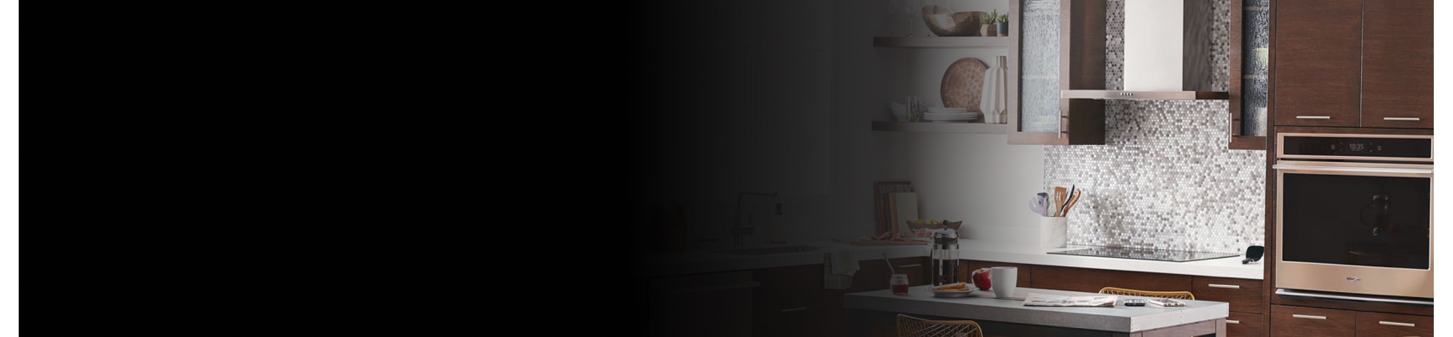 Range hood above an electric stovetop in front of a tile backsplash