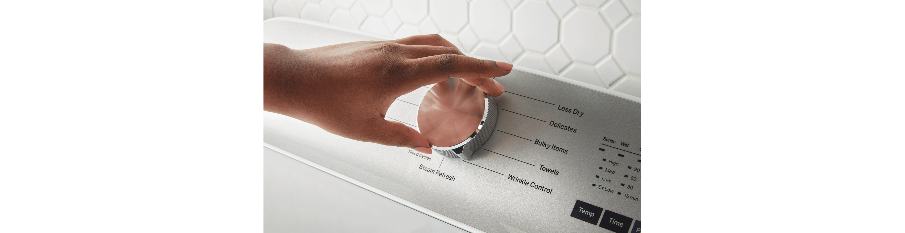 Hand making a dryer selection with a dial