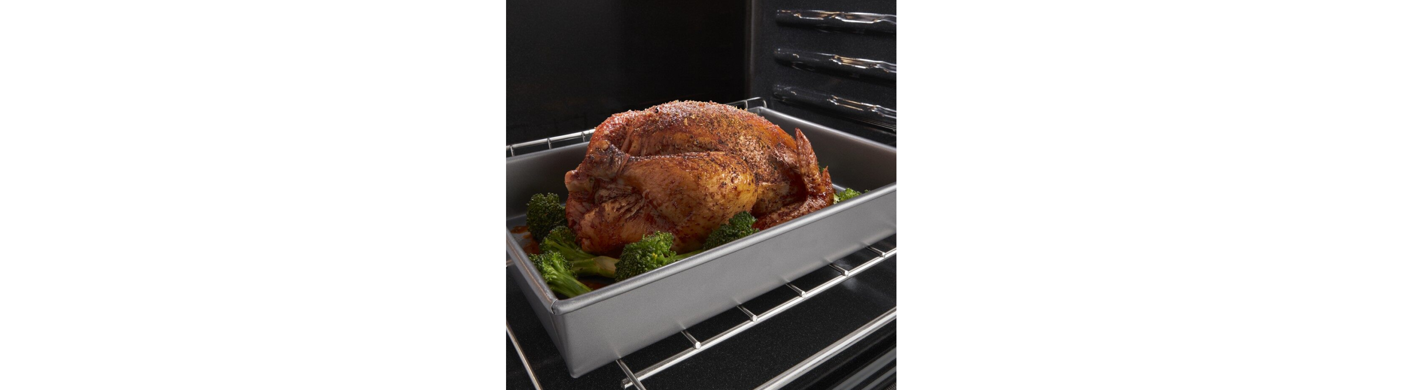 Cooked turkey in a roasting pan with vegetables