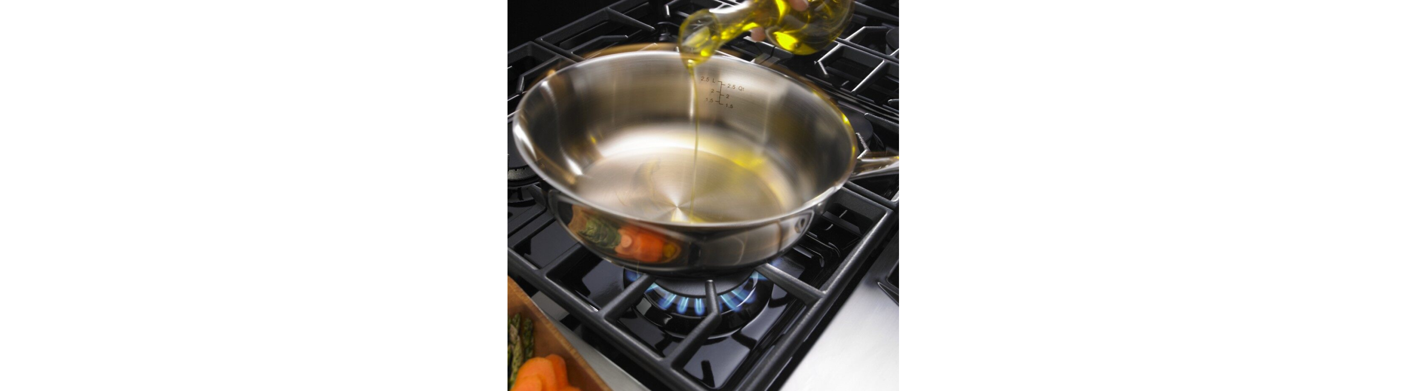 Oil being poured into a saucepan on an active stovetop