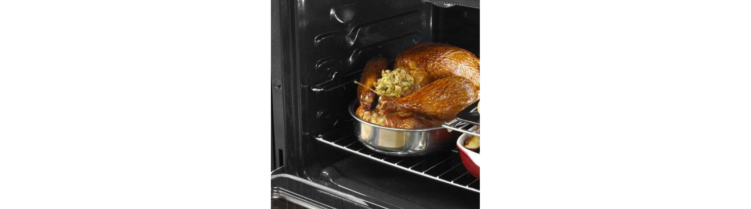 A stuffed, cooked turkey in the oven with other dishes