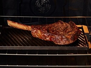 Grilling a steak inside a Maytag® range