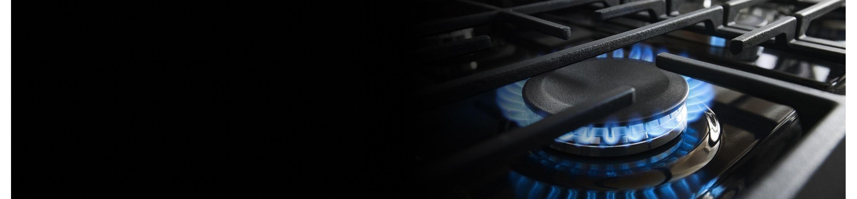 Close-up of blue flame on a gas cooktop burner