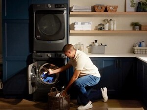 Person removing laundry from stacked  Maytag® front load washer and dryer