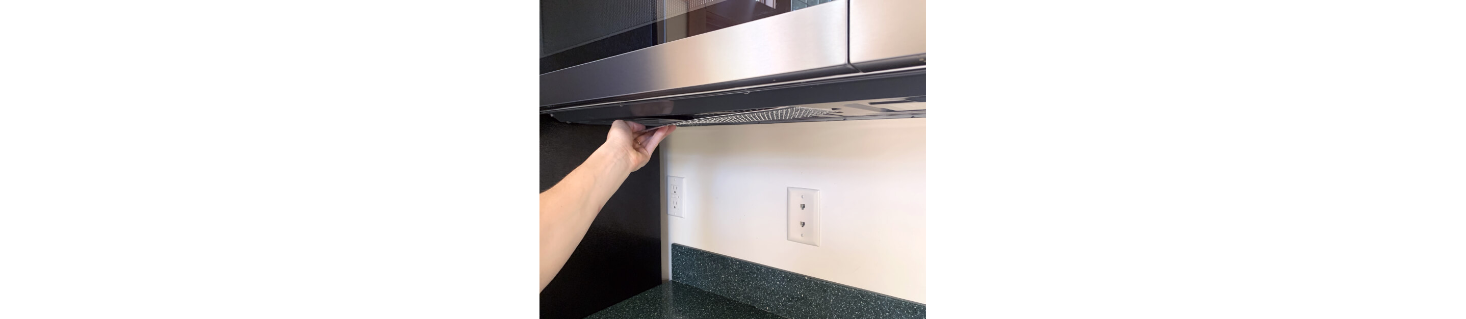 Hand placing filter back onto its position within microwave 