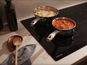 Pasta and pasta sauce cooking in two pots on a Maytag® induction cooktop