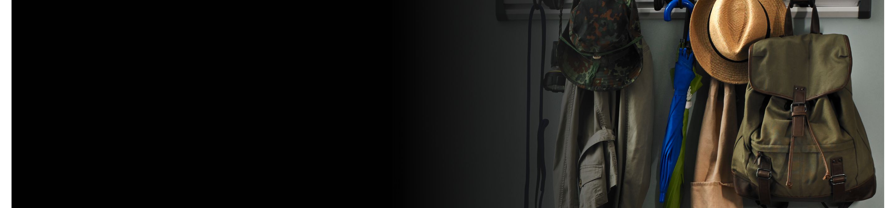  A closeup of a coat rack with jackets, a canvas backpack and hat.