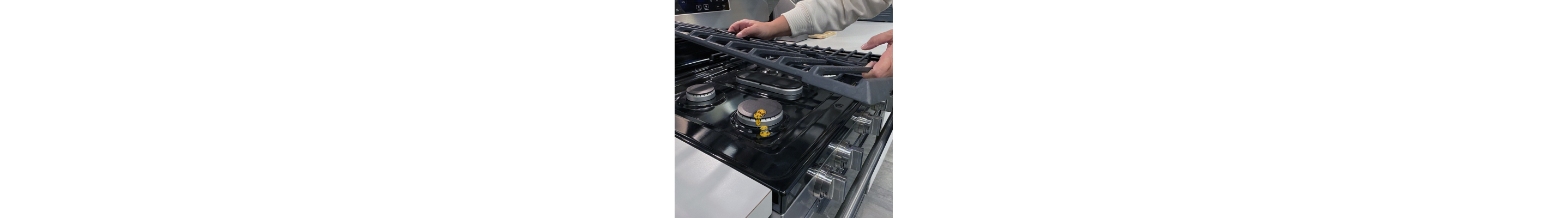 Person removing grates from a gas stovetop
