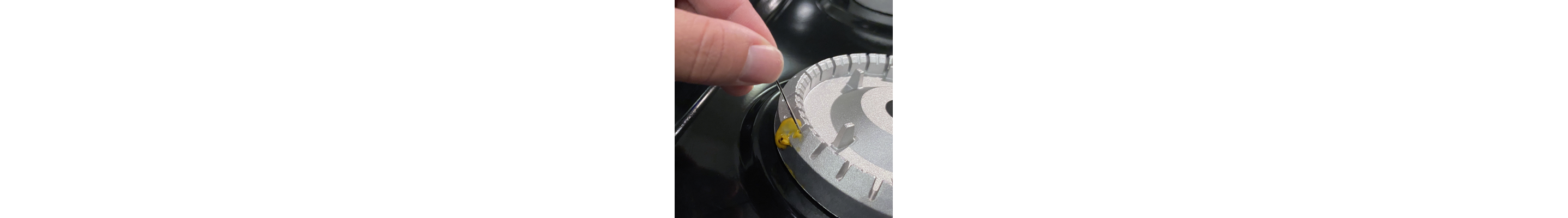 Removing cheese from burners with a needle