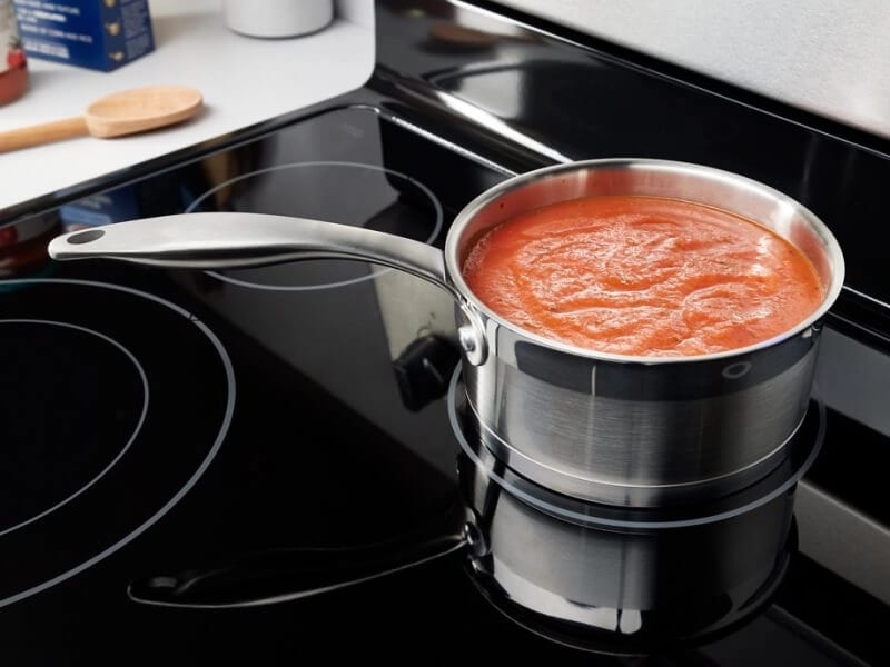 Tomato sauce in a an aluminum pot on the stove