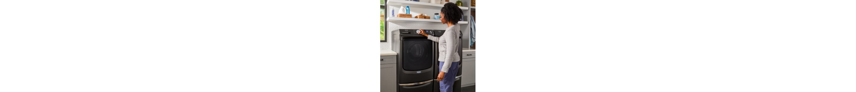 Person selecting a setting on a front load washing machine