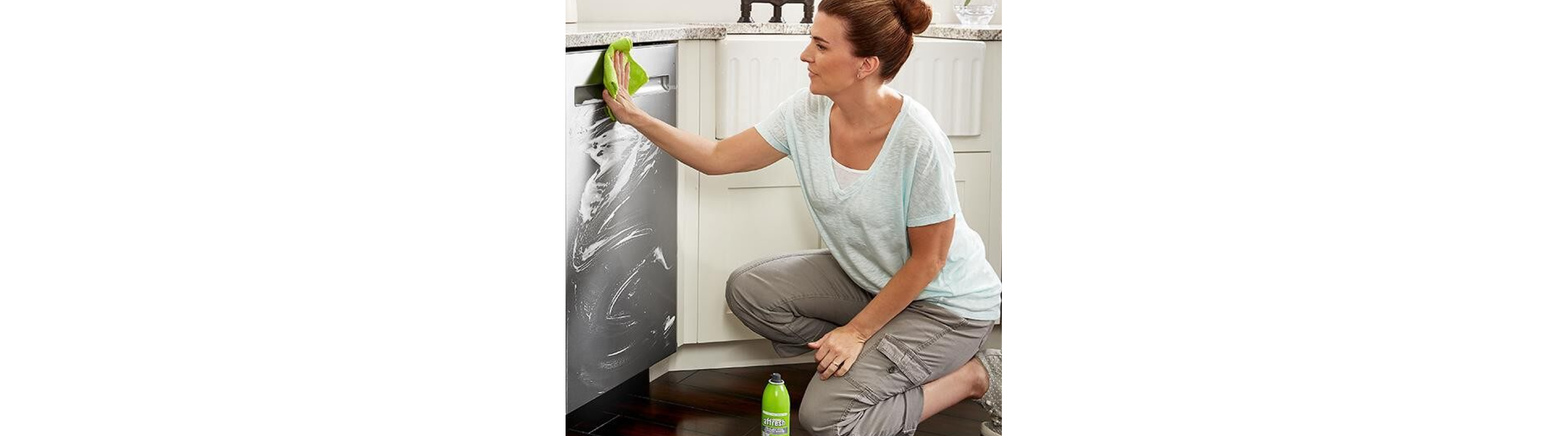 Person cleaning stainless steel dishwasher with affresh® cleaner