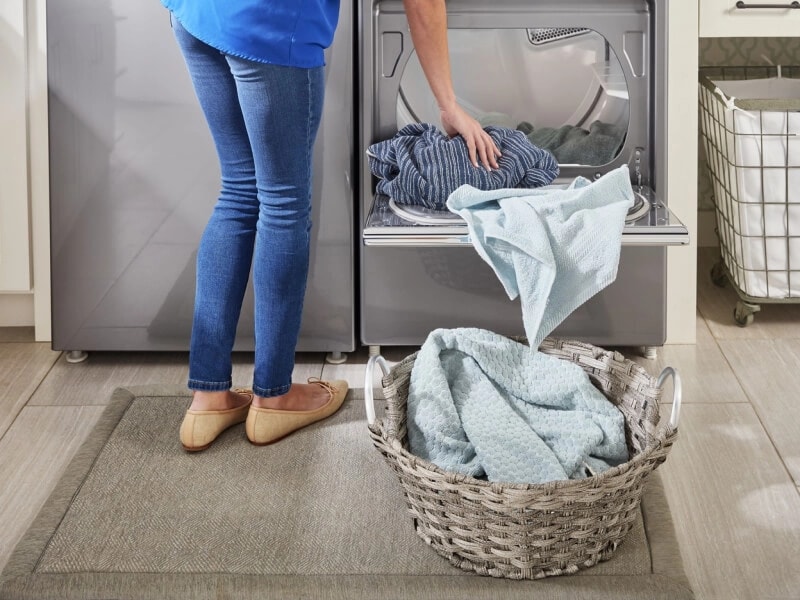 A person unloading laundry out of their dryer