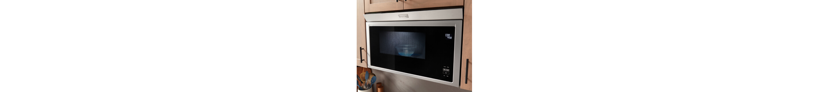 Maytag® built-in microwave surrounded by light-colored cabinets