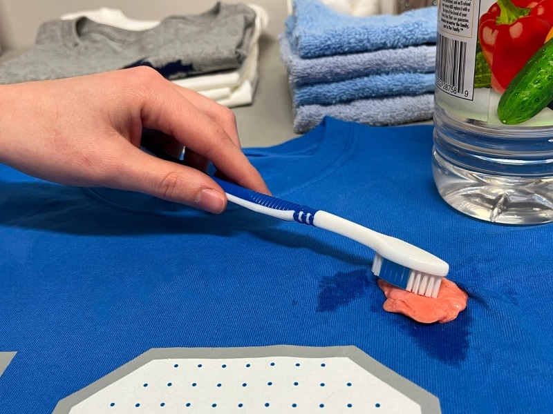 Person scrubbing gum with a toothbrush