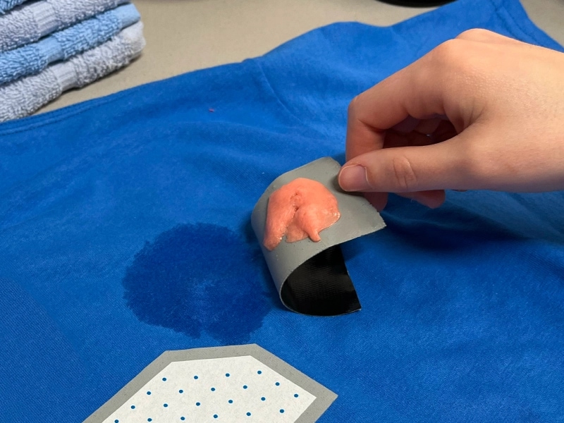 Person removing gum from a jersey with a piece of tape