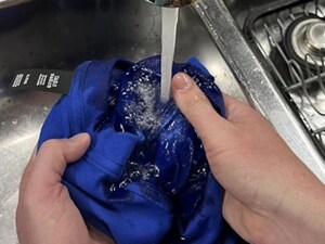 Person rinsing a blue shirt