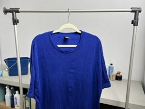 Blue shirt with paint removed hanging to dry in a laundry room