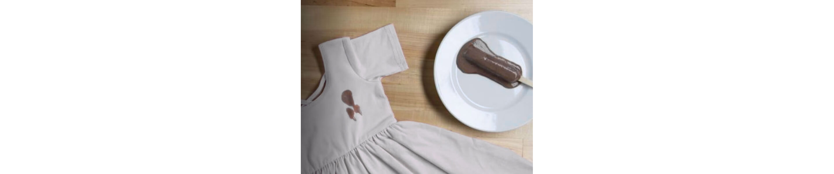 Chocolate popsicle next to a dress with a brown popsicle stain