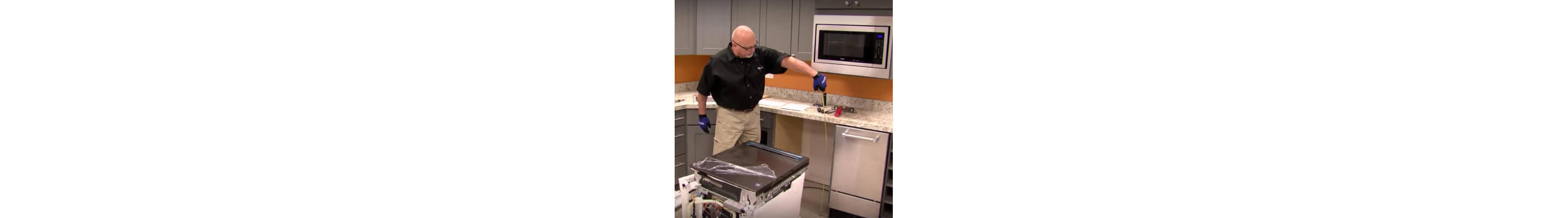 A person measuring space for installing a dishwasher