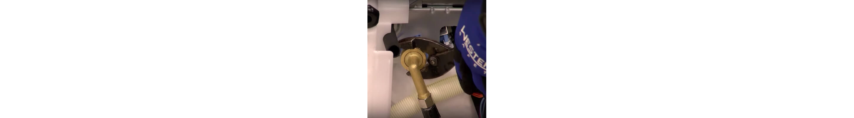 A close up of a wrench and water supply line