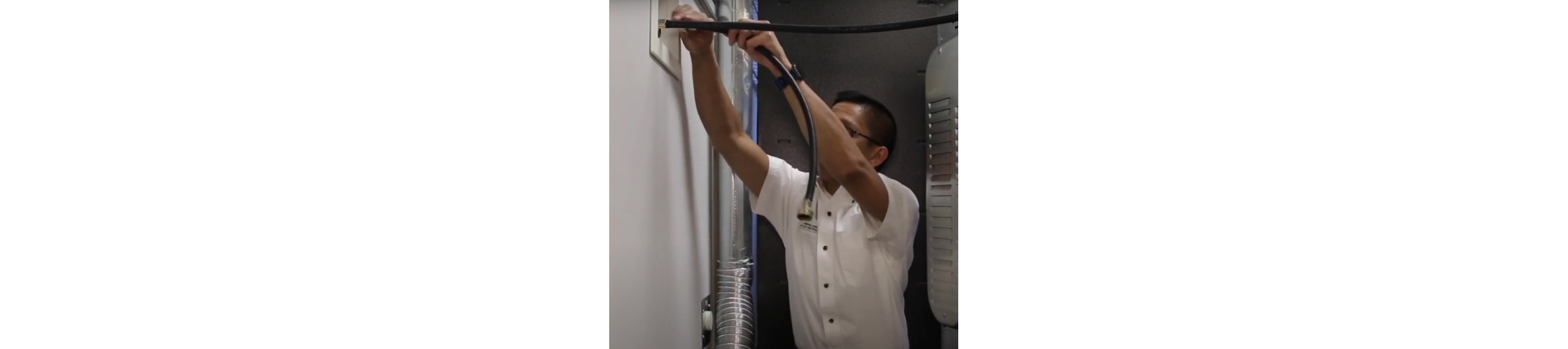 A man attaches a water inlet hose to a cold water inlet