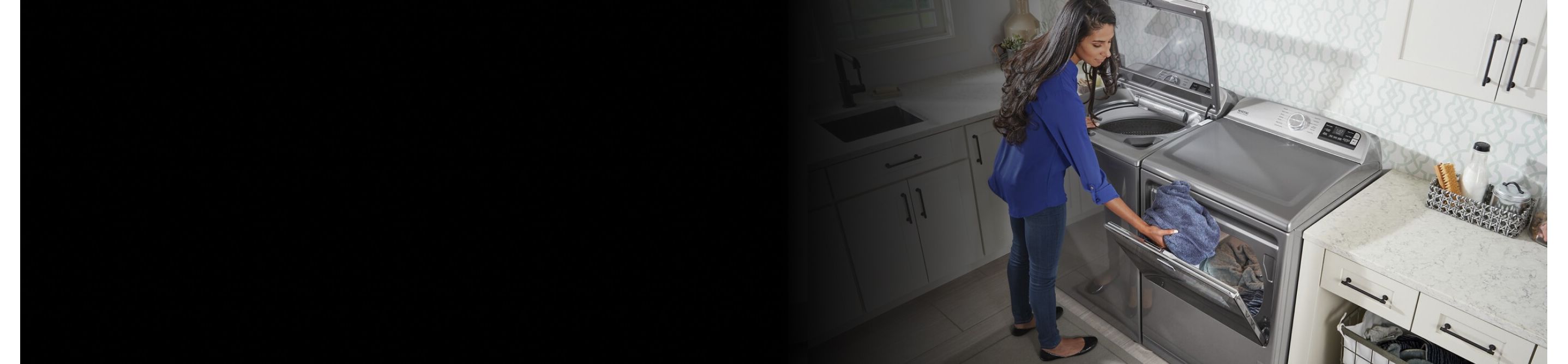 A person switching clothes between a washer and a dryer