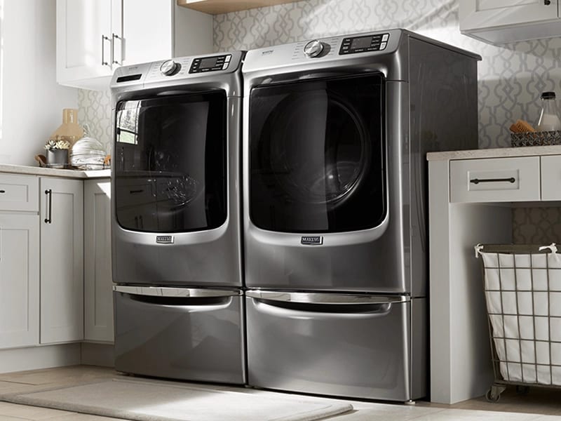 A stainless steel Maytag® washer and dryer pair in a laundry room