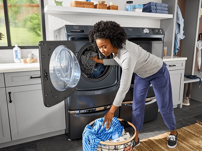 A person putting clothes in a washing machine