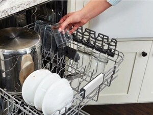 Person loading dishes into a dishwasher top rack
