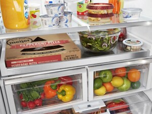 Various food items on the shelves and in the bins of a refrigerator