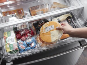 A person taking cheese out of a fridge drawer