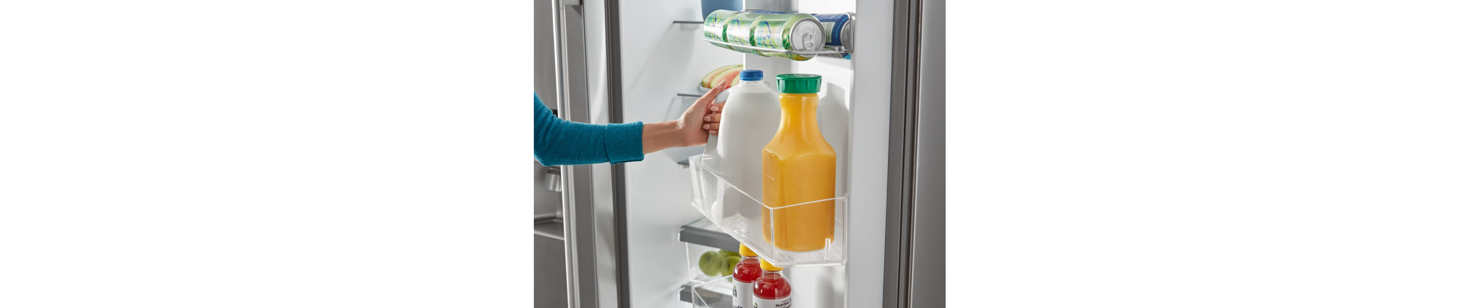 Person placing a jug of milk in a refrigerator door bin