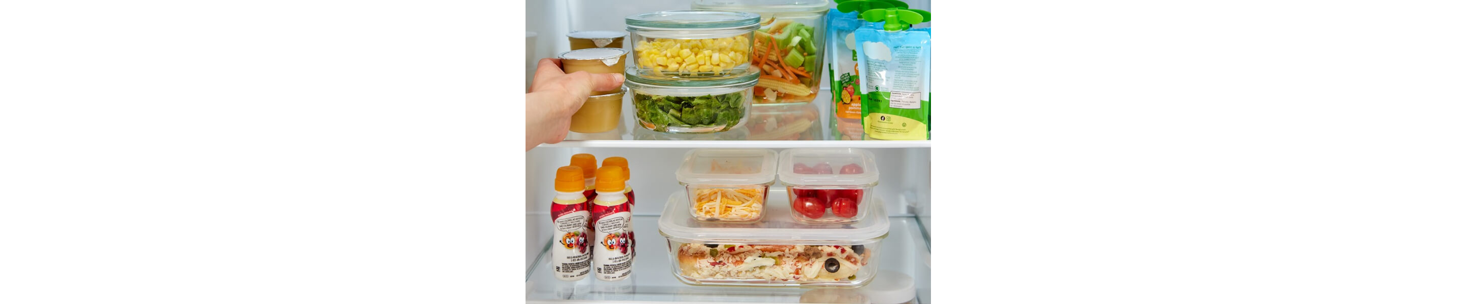 Person stacking groceries inside a refrigerator
