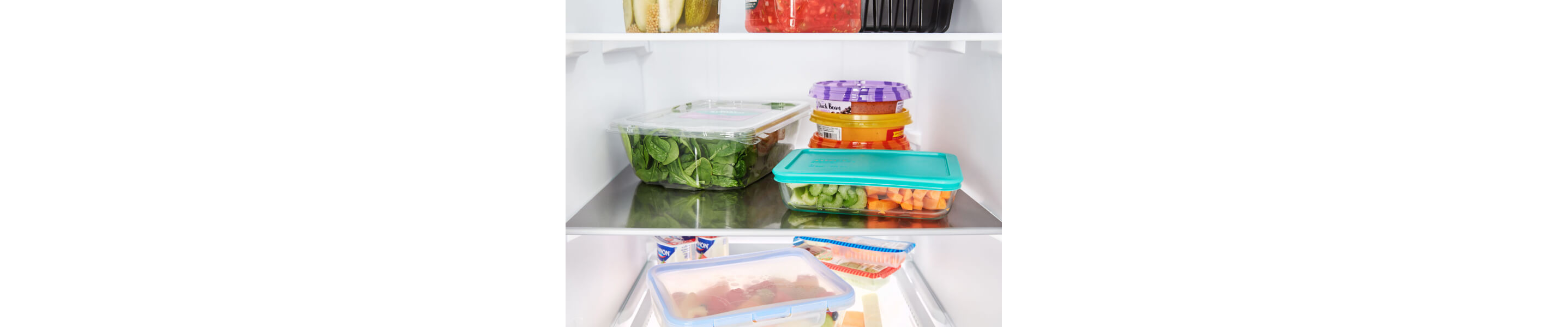 Containers of fresh ingredients stored on fridge shelves