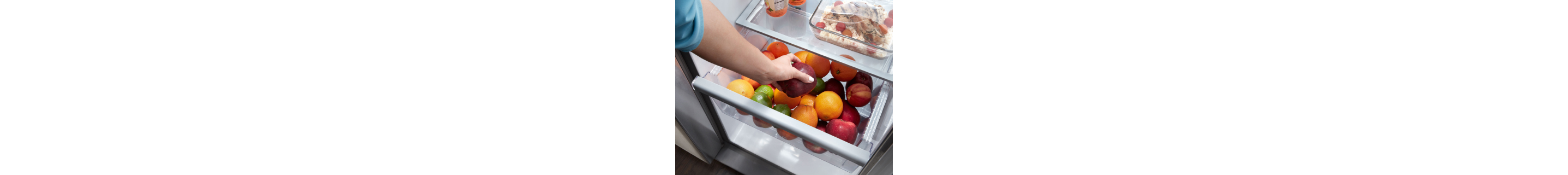 A person storing apples in a fridge crisper drawer
